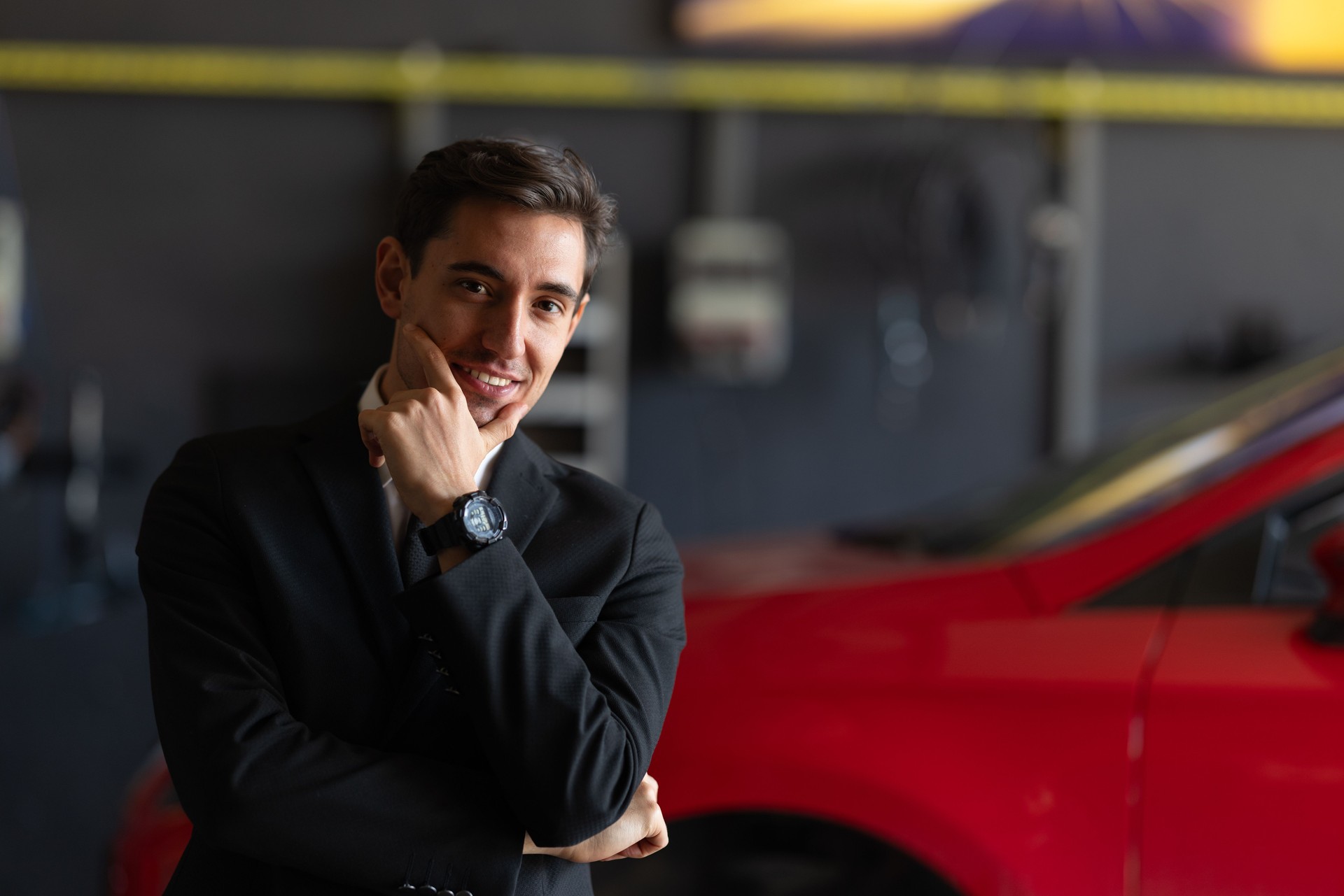 Confident Businessman Smiling in Car Workshop Setting